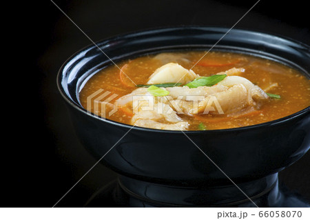 Japanese Soup With Chicken, Egg, Simeji Mushrooms and Eggplant On a Dark Background in a black plate. close up Japanese Soup With Chicken, Egg, Simeji Mushrooms and Eggplant On a Dark Background in a black plate. close up 66058070
