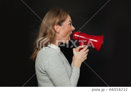 Angry woman screaming with loudspeaker megaphone Angry woman screaming with loudspeaker megaphone 66058232