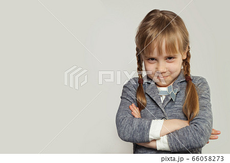 Funny little child girl with crossed arms on white 66058273