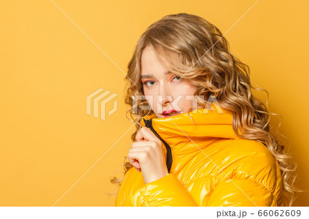 Attractive woman in yellow winter jacket Attractive woman in yellow winter jacket 66062609