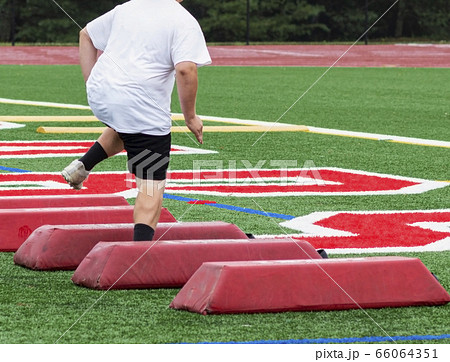 Rear view of teenage football lineman running Rear view of teenage football lineman running 66064351