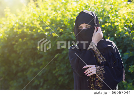 Beautiful muslim woman on a background of green 66067044