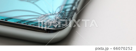 Modern smartphone lying at table with crack in corner 66070252