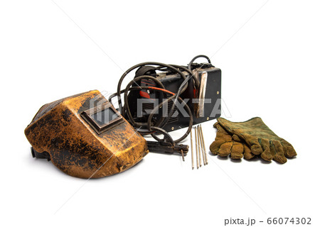 Aged welding mask with welding machine, protective gloves, and arc steel electrodes isolated on white background. Kit of welder time-tested 66074302