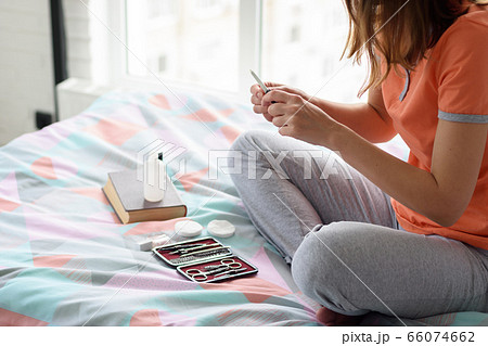 Girl treats nails with a nail file, sitting on a Girl treats nails with a nail file, sitting on a 66074662