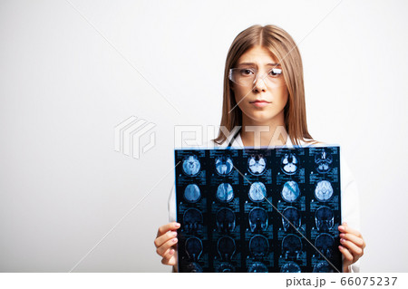 A young doctor examines an MRI image of a patient 66075237