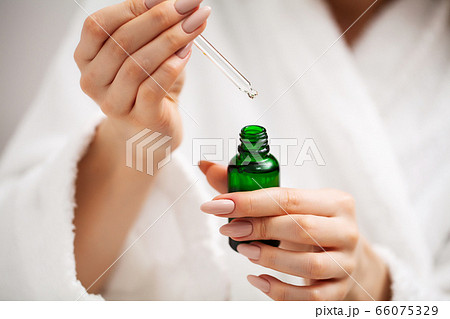 A woman uses a moisturizer to take care of her skin 66075329