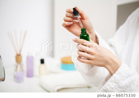 A woman uses a moisturizer to take care of her skin 66075330