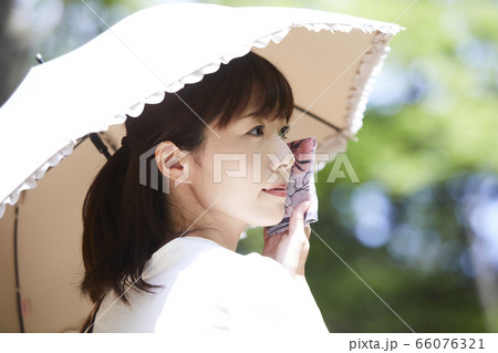 日傘をさす若い女性 66076321