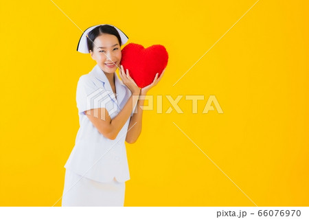 Portrait beautiful young asian woman thai nurse show heart pillow shape 66076970