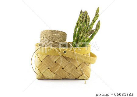 Fresh green asparagus in a rustic woven basket 66081332