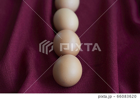 Natural eggs on red tablecloth, several brown 66083620
