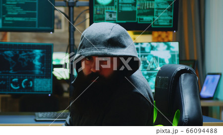 Dangerous hacker wearing a hoodies and looking into the camera Dangerous hacker wearing a hoodies and looking into the camera 66094488