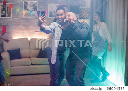 Man and beautiful woman using smartphone taking a selfie 66094535