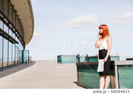 Young redhead business woman in formal outside 66094615