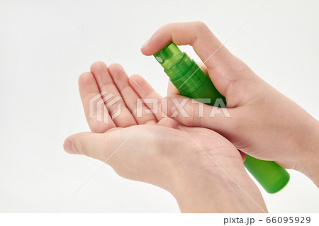 A small girl hand is spraying hand sanitizer. 66095929