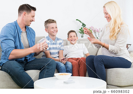 Happy young family playing card game at home. Happy young family playing card game at home. 66098302