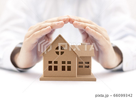 Property insurance. House miniature covered by hands. 66099342