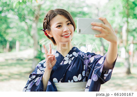 スマホで自撮りをする浴衣の女性 の写真素材