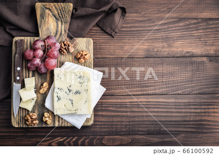 Slice of Gorgonzola cheese on cutting board Slice of Gorgonzola cheese on cutting board 66100592