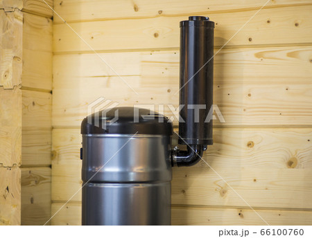 Detail of a chimney on wooden home. Chimney with two steel pipes. Roof and chimney of family house. Detail of a chimney on wooden home. Chimney with two steel pipes. Roof and chimney of family house. 66100760