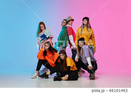 Group of dancers, boys and girls dancing hip-hop in stylish clothes on gradient studio background in neon light. Group of dancers, boys and girls dancing hip-hop in stylish clothes on gradient studio background in neon light. 66101463