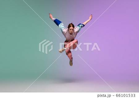 Girl dancing hip-hop in stylish clothes on gradient background at dance hall in neon light. 66101533