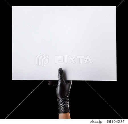 Hand in black gloves holding blank cardboard isolated on black 66104285
