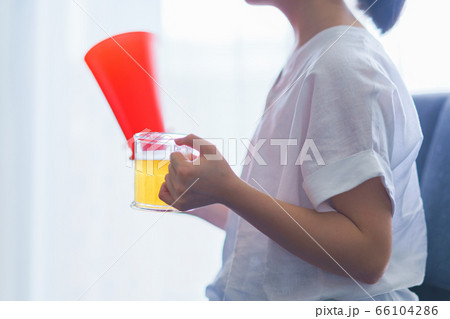 家でビール片手に推しを応援する若い女性のイメージ 家でビール片手に推しを応援する若い女性のイメージ 66104286
