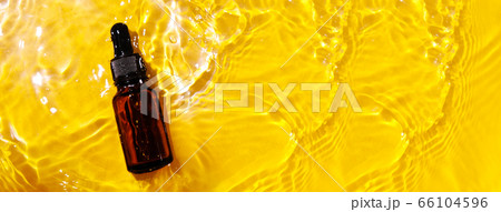 Essential oil in water on a yellow background. The Essential oil in water on a yellow background. The 66104596