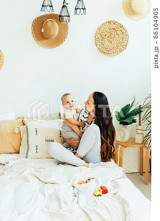 mom and baby cuddle on the bed 66104905