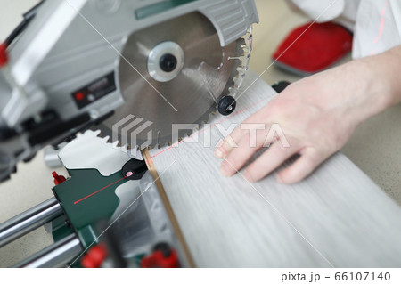 Man uses circular saw table while cutting laminate Man uses circular saw table while cutting laminate 66107140