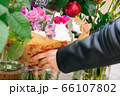 girl during pandemic illness chooses a gift in a flower shop. The concept of the holiday and the purchase of a bouquet during the coronavirus 66107802