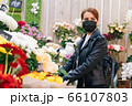 girl during pandemic illness chooses a gift in a flower shop. The concept of the holiday and the purchase of a bouquet during the coronavirus 66107803