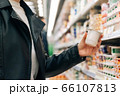 Close-up women's hands hold groceries in the store. The concept of buying fruits and vegetables in a hypermarket during quarantine 66107813