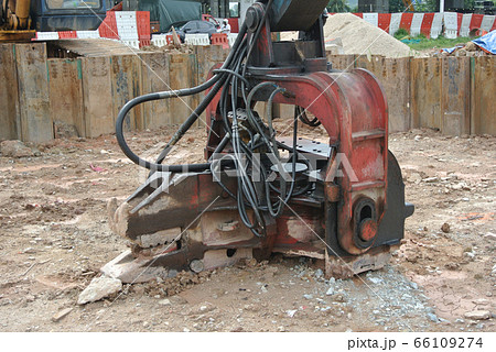 Sheet pile cofferdam driven machine at the construction site. The machine drove the sheet pile to the earth using vibrated hydraulic arm. Workers control. Sheet pile cofferdam driven machine at the construction site. The machine drove the sheet pile to the earth using vibrated hydraulic arm. Workers control. 66109274