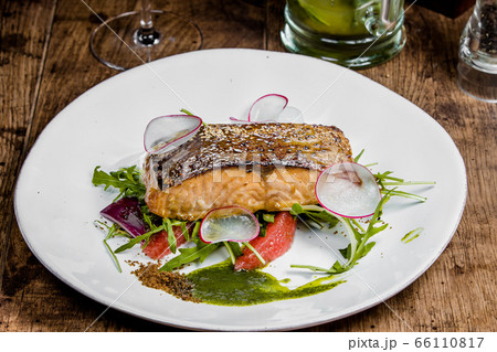 A piece of salmon steak on a white plate 66110817