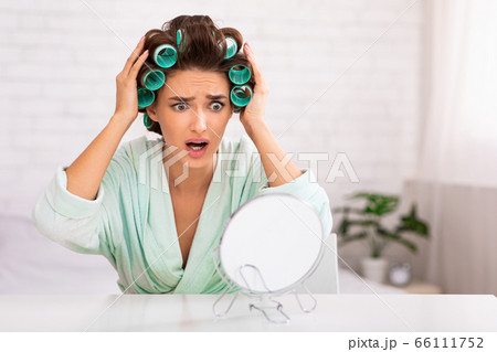 Unhappy Woman Touching Hair Curling It Sitting At Home Unhappy Woman Touching Hair Curling It Sitting At Home 66111752