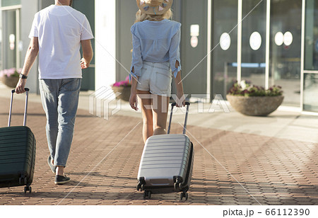 Tourists walking with baggage at airport terminal Tourists walking with baggage at airport terminal 66112390
