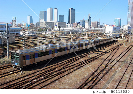 名古屋駅を背景に、名古屋車両区の横を走る あおなみ線（ささしまライブ付近） 66112689