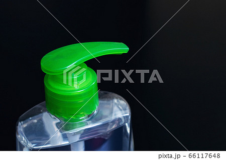 Green liquid soap dispenser black background close 66117648