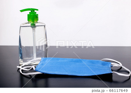 Bottle with disinfectant and medical masks on 66117649