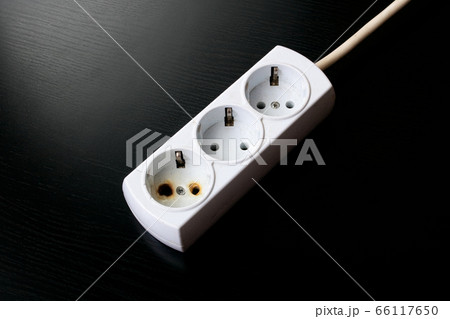 Old burnt extension cord on a black background 66117650