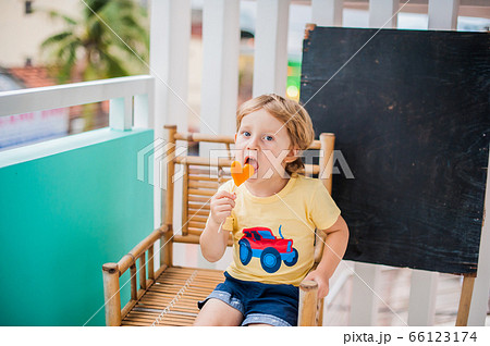 Boy drinking smoothie papaya. Healthy food concept. Black wooden board with space for text Boy drinking smoothie papaya. Healthy food concept. Black wooden board with space for text 66123174