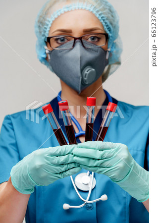 medical doctor nurse woman wearing protective mask and gloves - holding virus blood test tube 66123796