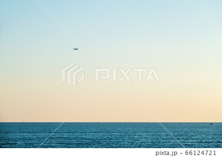 Airplane flying over sea water on sunset sky background Airplane flying over sea water on sunset sky background 66124721