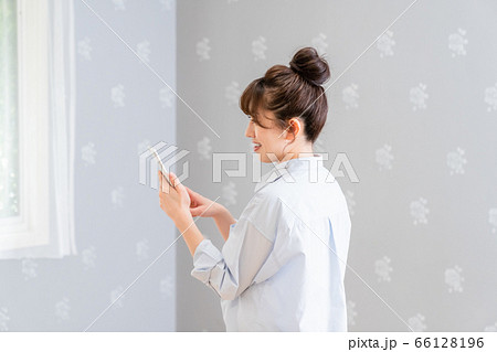こちらに背中を向けてスマホを眺める女性(横顔) こちらに背中を向けてスマホを眺める女性(横顔) 66128196