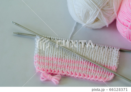 Pink and white yarn and needles on white background. Pink and white yarn and needles on white background. 66128371