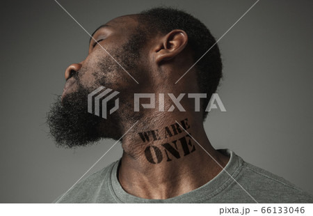 Close up portrait of a black man tired of racial discrimination has tattooed slogan on his neck 66133046