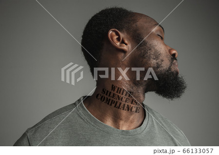 Close up portrait of a black man tired of racial discrimination has tattooed slogan on his neck 66133057